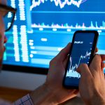 Trader analizuje wykresy na telefonie i komputerze, aby wykorzystać Pivoi Points