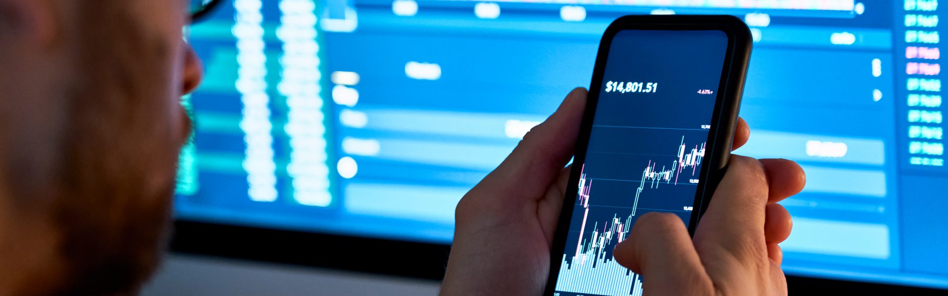 Trader analizuje wykresy na telefonie i komputerze, aby wykorzystać Pivoi Points